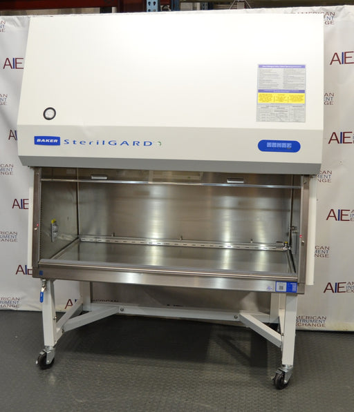 Front eye-level view of a Baker SterilGARD e3 SG504 biosafety cabinet on a mobile locking stand, showcasing its white cabinet exterior, sloped top section with instruction placard, and a spacious stainless steel work area enclosed by a clear sash