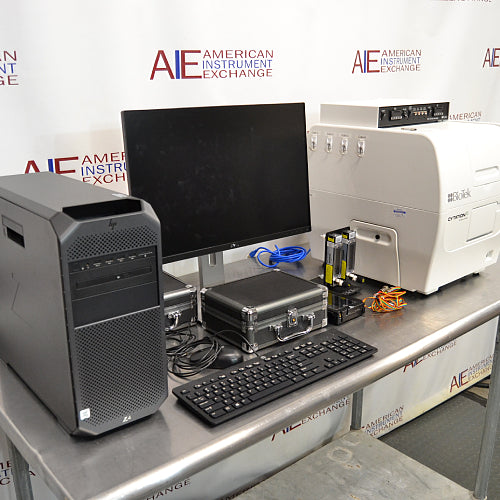 Comprehensive front angled view of a BioTek Cytation 5 cell imaging multimode reader system on a stainless steel counter, featuring an HP Z workstation tower, monitor, keyboard, mouse, accessory cases, and gas controller module