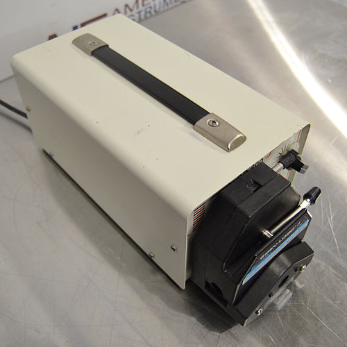 Right three-quarter angle product view of a BRL CP-600 peristaltic pump with a Masterflex 77201-62 Easy-Load II pump head, off-white enclosure, and carrying handle resting on a stainless steel lab bench