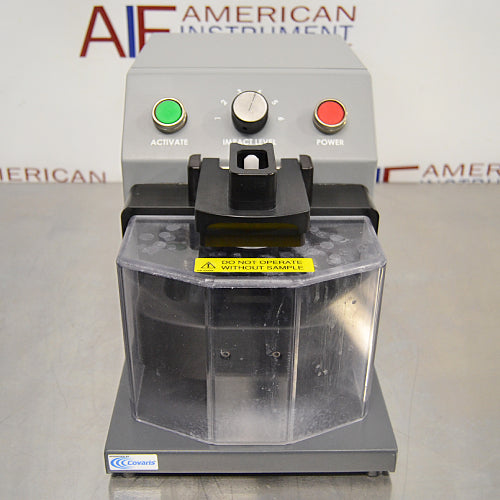 Front product view of a Covaris cryoPREP CP02 dry pulverizer, featuring its grey housing, clear protective front safety shield, central impact level dial, green activate button, and red power button