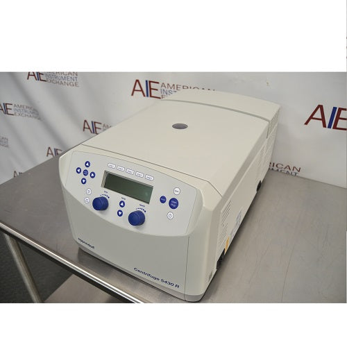 Left angled perspective view of Eppendorf 5430 R refrigerated microcentrifuge with closed lid on stainless steel table showing front digital control panel