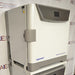 Left three-quarter angle product view of an Eppendorf New Brunswick S41i CO2 incubator with integrated shaker, showcasing the side housing panel, door latch, top digital control console, and mounting brackets on a support stand