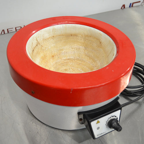 Right three-quarter angle product view of a Fisatom laboratory heating mantle, highlighting its red rim, white base, internal fabric heating element, front control knob, and coiled power cord on a lab bench