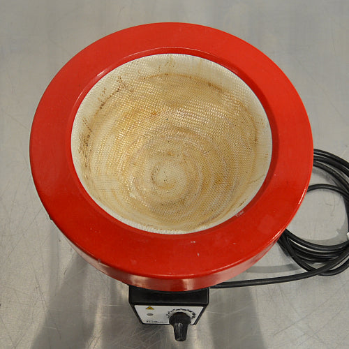 Top-down product view of a Fisatom laboratory heating mantle, showcasing the circular red rim, woven heating fabric interior well, control knob, and coiled power cable on a lab bench