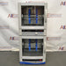 Front product view of a Fisher dual chamber hybridization incubator against a branded backdrop, highlighting its stacked design, two glass-window doors with vertical handles, internal rotating bottle racks, and digital control panels