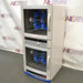 Right three-quarter angle view of a Fisher dual chamber hybridization incubator, highlighting its stacked configuration, side panels, dual glass-window doors with vertical handles, and internal blue bottle rotisserie wheels