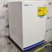 Front angled perspective view of a Fisher Scientific Isotemp general purpose undercounter freezer resting on a wheeled cart, featuring a white cabinet body, solid door with Fisherbrand branding, and a yellow warning label