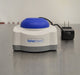 Front eye-level view of Fisherbrand mini vortex mixer showing blue rubber head, front logo plate, and AC power adapter on the side