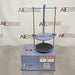 Straight-on front view of a Gilson 8-inch sieve shaker, featuring its blue cabinet housing, vertical clamping rods, safety warning labels, brand logo, and control interface on a stainless steel lab bench