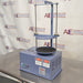 Three-quarter angle product view of a Gilson 8-inch sieve shaker, highlighting its blue housing, vertical clamping rods, timer control panel, and testing platform on a stainless steel lab bench