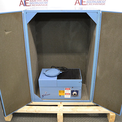 Front product view of a Gilson sieve shaker inside a sound enclosure with open acoustic foam-lined doors, showcasing the blue sieve shaker unit resting on a wooden pallet base