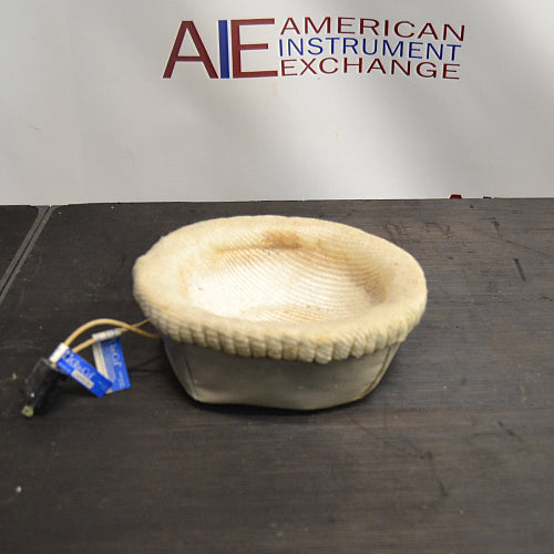 Front product view of a Glas-Col 2L laboratory heating mantle, featuring its soft-sided fabric construction, internal hemispherical heating well, and power cord with connector on a dark work surface