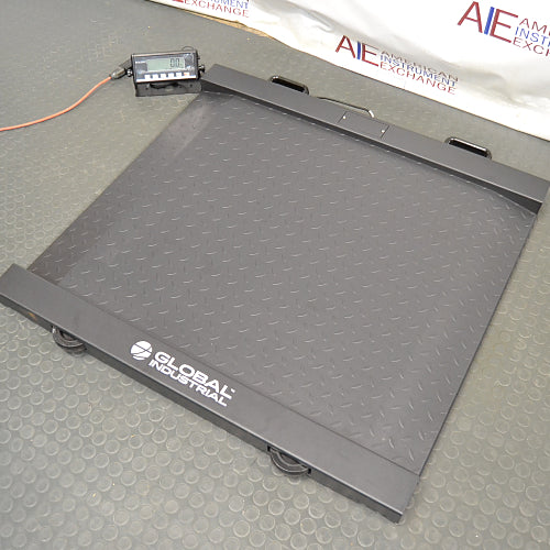 Elevated three-quarter product view of a Global Industrial 318506 drum scale, showcasing the connected digital LCD indicator console, diamond plate steel platform, and integrated ramp profile