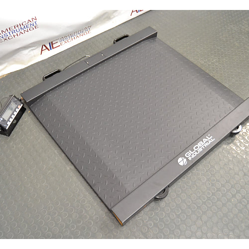 Three-quarter angle product view of a Global Industrial 318506 drum scale with an LCD indicator, highlighting the low-profile diamond plate weighing platform, ramps, and digital display terminal on a floor