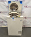 Front eye-level view of a Hirayama HV-50II vertical autoclave demo unit with its top lid open, revealing the stainless steel inner chamber, white cabinet body, blue control lever, pressure gauge, and exhaust bottle compartment