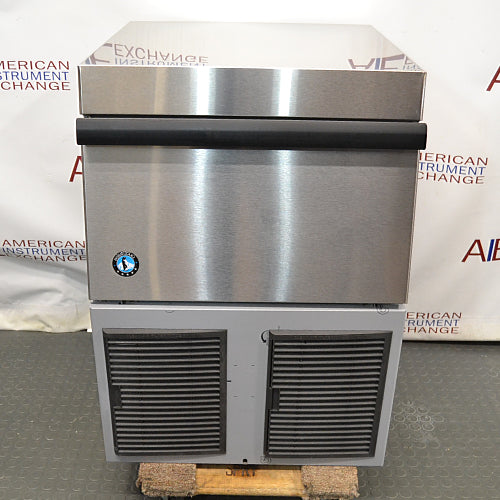 Front product view of a Hoshizaki F330 BAJ flaker ice maker, showcasing its stainless steel bin door with a black handle, polished top housing, and lower louvered panels