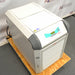 Left three-quarter angle product view of a Julabo FL1701 recirculating chiller, highlighting its white and gray housing, angled digital control panel, lower vented louvered door, and power cord on a wooden pallet base
