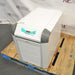 Right angled perspective view of Julabo FL1703 recirculating chiller resting on a wooden pallet highlighting top panel, digital display interface, and front ventilation grill