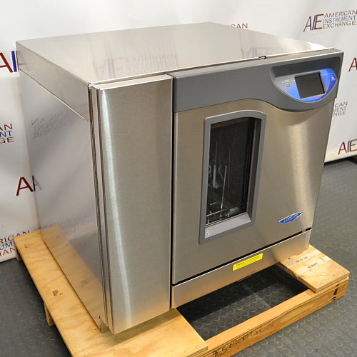 Three-quarter angle product view of a Labconco FlaskScrubber Vantage 422101010 glassware washer, highlighting the stainless steel side panel, digital display console, and glass viewing window on a wooden pallet