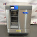 Front eye-level view of a Labconco Freestanding Glassware Washer (Model 4420430) on a dark textured surface, featuring its stainless steel and gray housing, blue control panel insert, Labconco FlaskScrubber branding badge, and a lower-tier drop-down glass door revealing internal wire racks