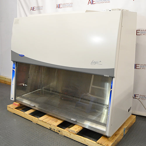 Left angle product view of a Labconco Purifier Logic+ Type A2 biosafety cabinet, featuring its stainless steel interior deck, closed glass sash, and white exterior housing on a wooden pallet