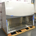 Left angle product view of a Labconco Purifier Logic+ Type A2 biosafety cabinet, featuring a stainless steel interior workspace, glass sash, and exterior housing on a wooden shipping pallet