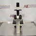 Leica DM IRB inverted research microscope ka front view, jisme dual eyepieces wala binocular head, stage platform, vertical camera/illumination tube, aur Leica branding saaf dikhai de rahe hain.