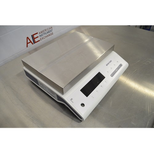 Angled perspective view of Mettler Toledo MS32001L A03 precision balance resting on stainless steel lab bench, displaying weighing pan and front keypad display