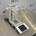 Angled perspective view of Mettler Toledo XPE26 microbalance showing glass draft shield enclosure, internal weighing chamber, rear housing, and front touchscreen control console