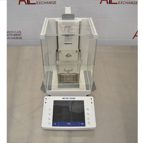Front view of Mettler Toledo XPE26 microbalance featuring a glass draft shield enclosure, internal weighing chamber, and detached front touchscreen control terminal