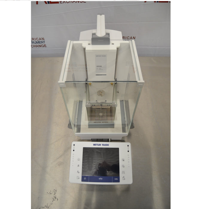 High-angle front view of Mettler Toledo XPE26 microbalance showing top draft shield structure, internal micro-weighing chamber, and touchscreen control unit