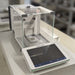 Mettler Toledo XPR106H dual-range analytical balance ka front angle view, jisme glass draft shield, precision weighing pan, aur front par laga hua large digital touch screen terminal saaf dikhai de raha hai.   