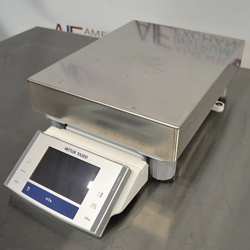 Front three-quarter product view of a Mettler Toledo XS32001L precision balance, highlighting its stainless steel pan, leveling knobs, and front digital display terminal