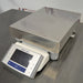 Front three-quarter product view of a Mettler Toledo XS32001L precision balance, highlighting its stainless steel pan, leveling knobs, and front digital display terminal