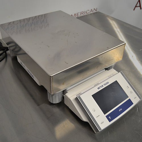 Front three-quarter product view of a Mettler Toledo XS32001L precision balance, showcasing its stainless steel weighing platform, leveling feet, and angled digital control terminal