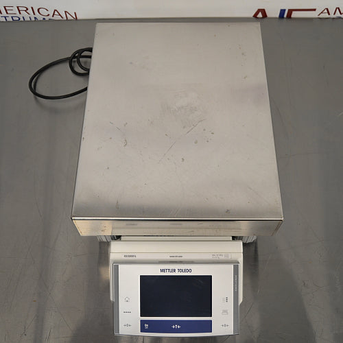 Top-down product view of a Mettler Toledo XS32001L precision balance, showcasing its large stainless steel weighing pan and front-facing digital control terminal