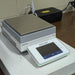 Three-quarter angle product view of a Mettler Toledo XSR10002S precision balance, featuring the stainless steel weighing platform, digital touchscreen terminal, and housing on a lab bench