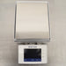 Top-down eye-level view of a Mettler Toledo XSR6002S Excellence precision toploading balance on a stainless steel surface, highlighting the flat rectangular stainless steel weighing pan and the front digital touchscreen terminal