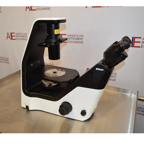 Right profile view of a Nikon Eclipse Ts2 inverted microscope on a stainless steel surface, highlighting its modern black-and-white ergonomic frame, stage, overhead illumination column, and angled binocular eyepieces