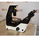 Right profile view of a Nikon Eclipse Ts2 inverted microscope on a stainless steel surface, highlighting its modern black-and-white ergonomic frame, stage, overhead illumination column, and angled binocular eyepieces