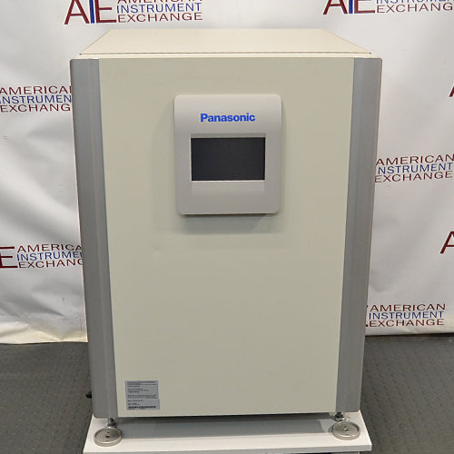 Studio front product view of a Panasonic Cell-IQ Series MCO-170AICUVL-PA CO2 cell culture incubator against a branded backdrop, highlighting its off-white outer cabinet, vertical silver side pillars, and central door-mounted digital touchscreen display featuring Panasonic branding