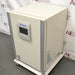 Studio right three-quarter angle product view of a Panasonic Cell-IQ Series MCO-170AICUVL-PA CO2 cell culture incubator against a branded backdrop, highlighting its off-white body, vertical silver corner trims, central Panasonic touchscreen display, right side panel labels, and wheeled platform base