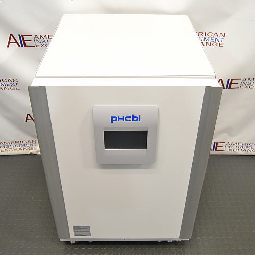 Studio top-down angle product view of a PHCBi Cell-IQ Series CO2 laboratory incubator against a branded backdrop, highlighting its flat white top surface, vertical silver corner pillars, and central door-mounted digital touchscreen interface panel