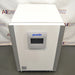 Studio top-down angle product view of a PHCBi Cell-IQ Series CO2 laboratory incubator against a branded backdrop, highlighting its flat white top surface, vertical silver corner pillars, and central door-mounted digital touchscreen interface panel