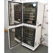 Left angled perspective view of stacked PHCbi Cell-IQ Series high heat sterilization CO2 incubators with outer and inner glass doors open showing stainless steel interior shelves