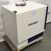 Front angled perspective view of a Precision 3EG incubator resting on a wooden pallet with casters, highlighting its white exterior housing, blue accent stripe on the door edge, and lower control panel