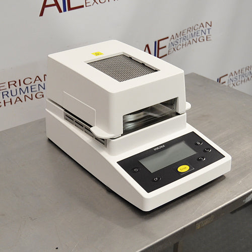 Left angle product view of a Sartorius MA35 infrared moisture analyzer, showcasing its white housing, top ventilation grill, heating chamber opening, and angled front control panel with a digital display