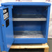 Front view of an unused Securall 24-gallon corrosive storage cabinet with its door swung open, revealing an empty interior compartment, protective shelf lining, and durable blue steel frame construction