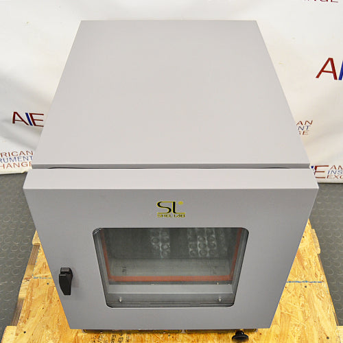 Top angled perspective view of a Shel Lab 1445 vacuum oven mounted on a wooden pallet, highlighting the flat top surface of its grey housing and the glass viewing door
