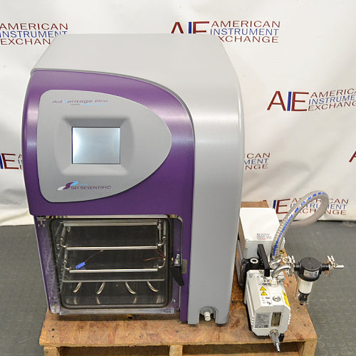 Elevated front product view of an SP VirTis AdVantage Pro laboratory freeze dryer, featuring a purple-and-gray chassis, digital control touchscreen, internal shelving chamber, and paired vacuum pump assembly on a wooden pallet